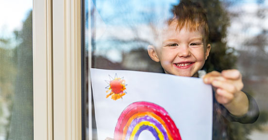 10 Tips for Entertaining Your Kids During COVID - A happy kis showing his artwork